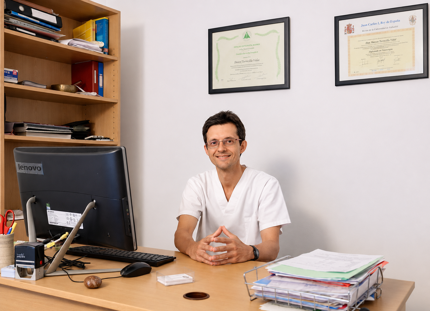Aitor Torrecilla en su consulta, junto a sus diplomas